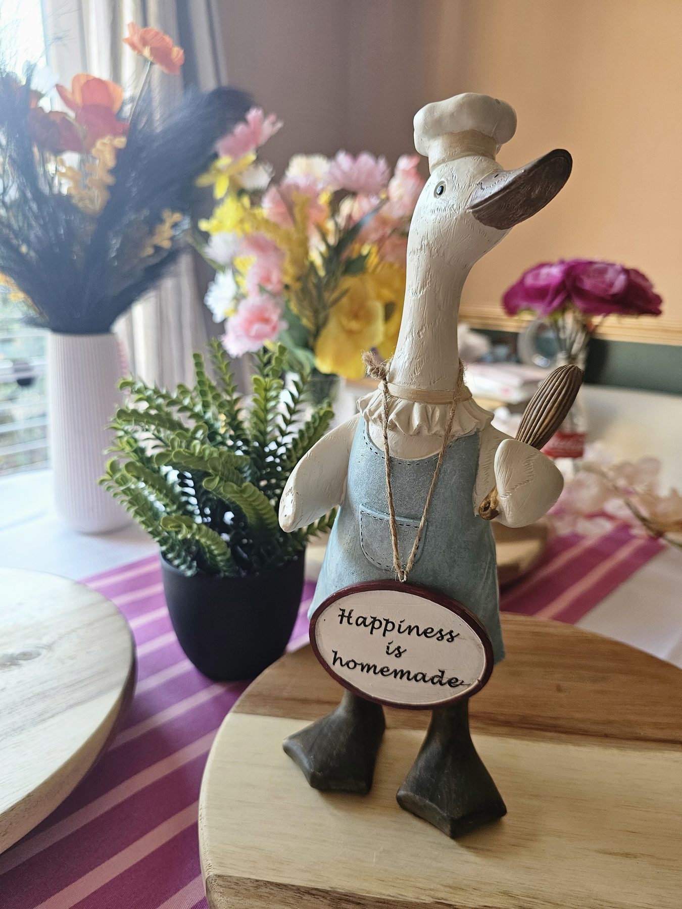 Full-length chef duck decoration with a Happiness is homemade sign